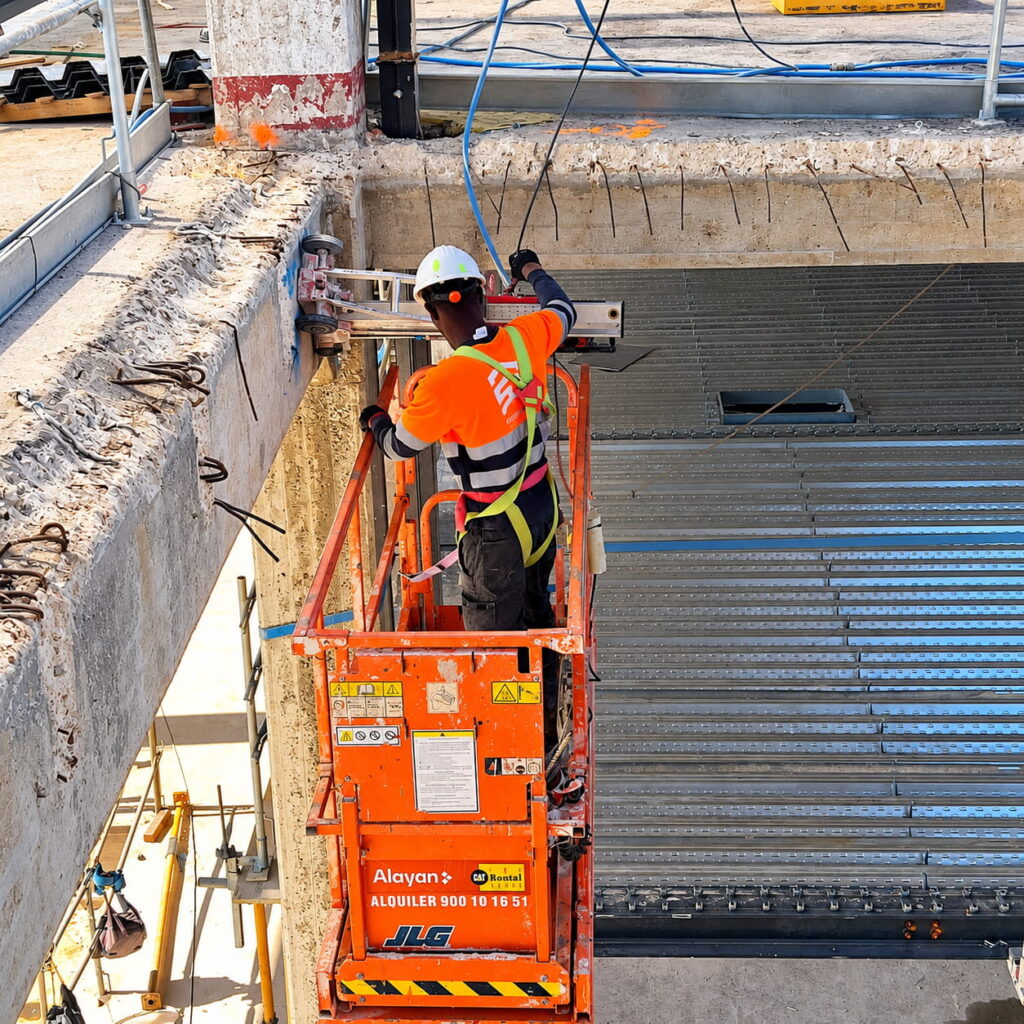 Trabajador en plataforma perforando hormigón